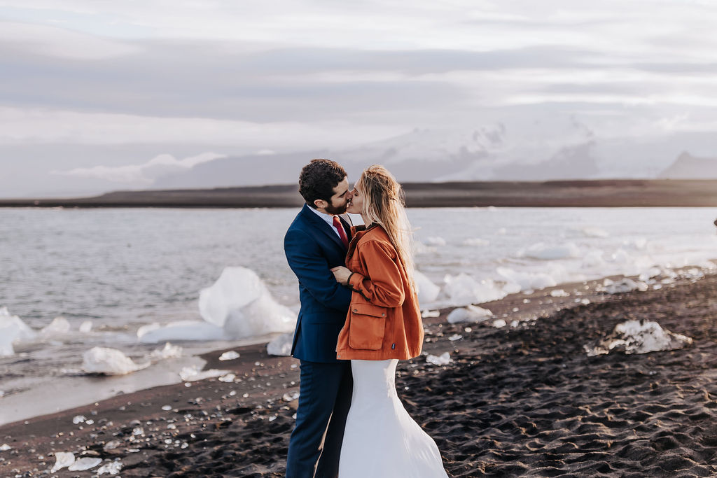 Iceland Elopement Photographer captures bride and groom kissing on black sand beaches