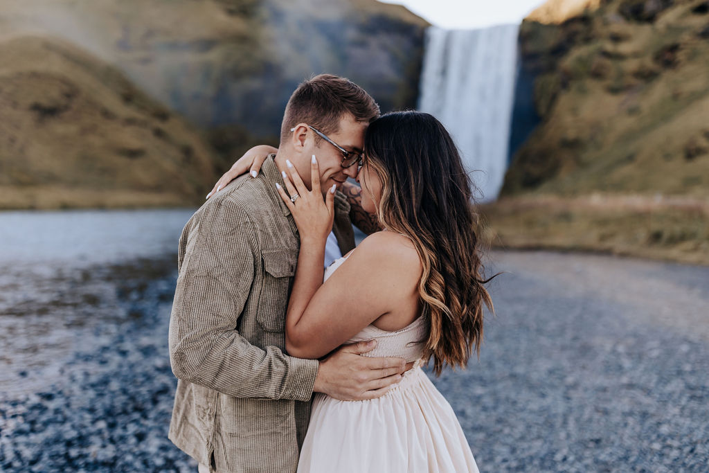 Destination Wedding Photographer captures man and woman embracing at waterfall 