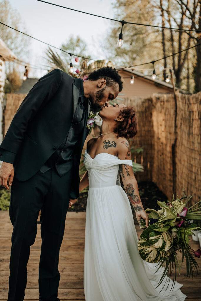 Nashville Elopement Photographer captures bride and groom kissing in front of East Nashville Greenhouse