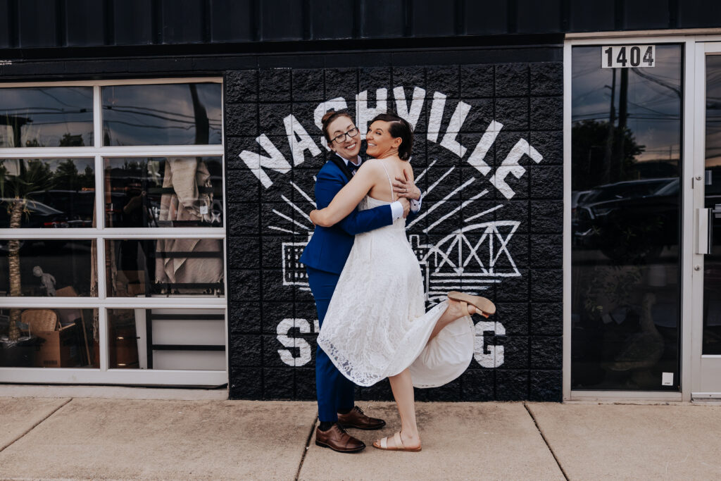 Destination Wedding Photographer captures couple embracing in front of Nashville sign after eloping in Nashville