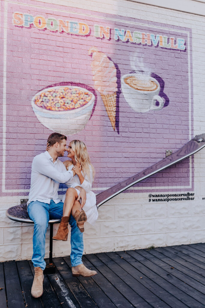 Nashville Engagement Photographer captures couple sitting on giant spoon outside of Wanna Spoon