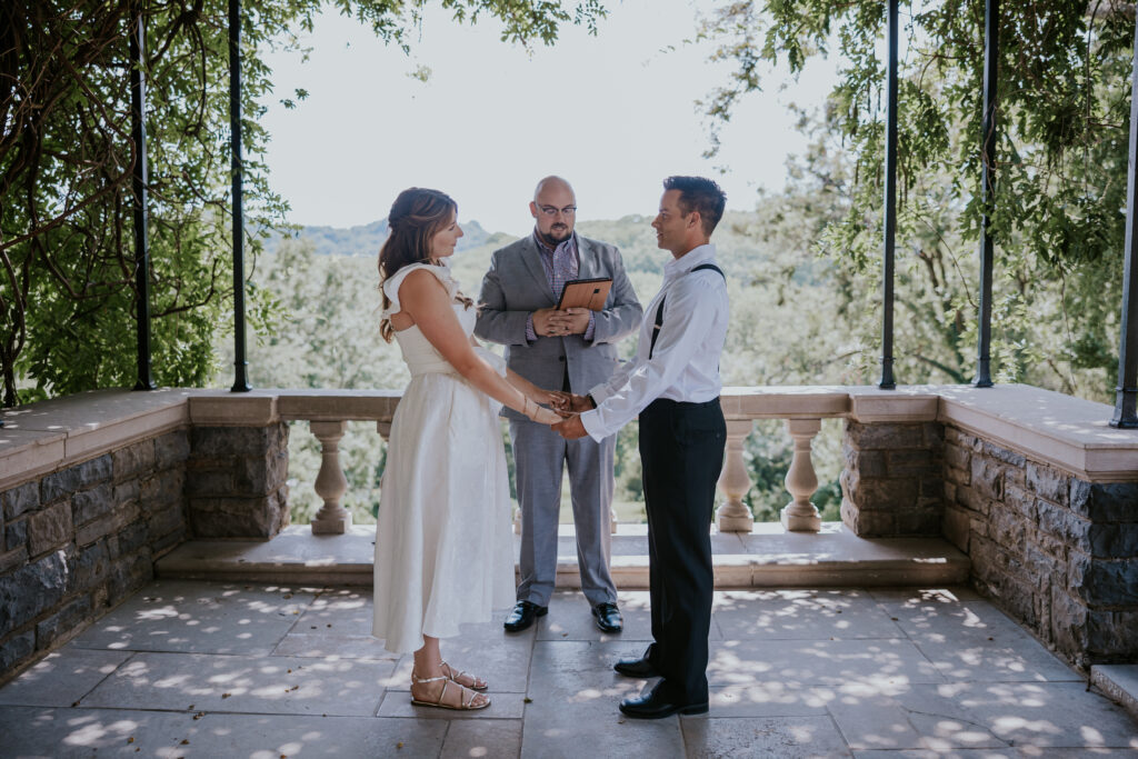 Destination Wedding Photographer captures bride and groom holding hands during vows after eloping in Nashville