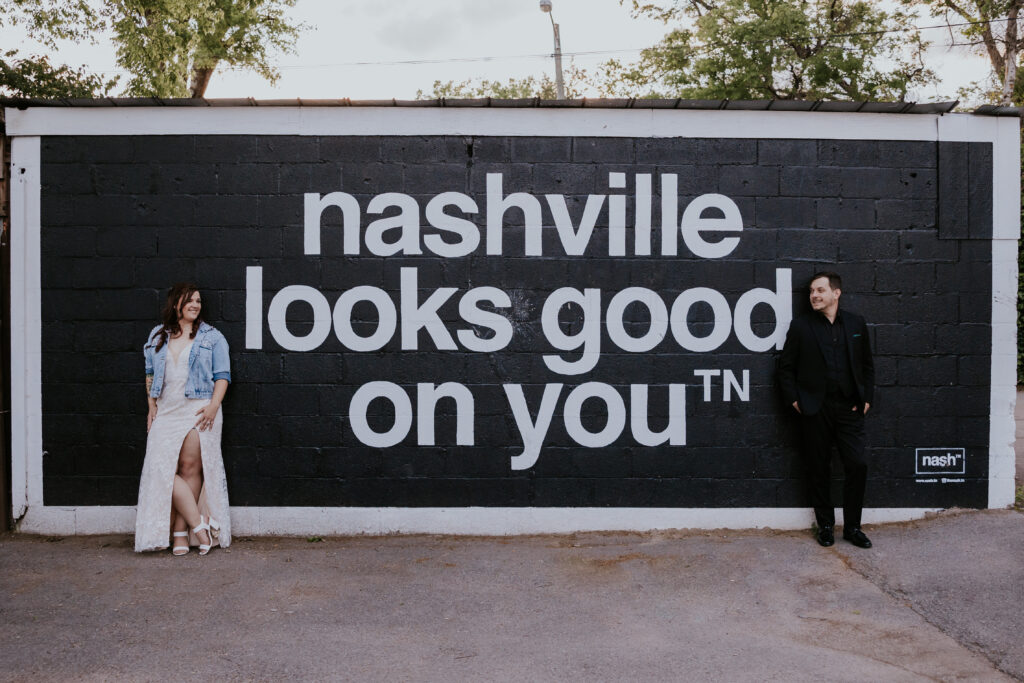 Destination Wedding Photographer captures couple standing against Nashville sign after eloping in Nashville