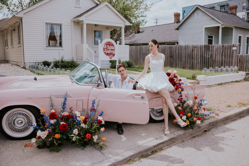 Nashville Elopement Photographer captures bride and groom inside pink car in front of White Velvet Chapel in Nashville