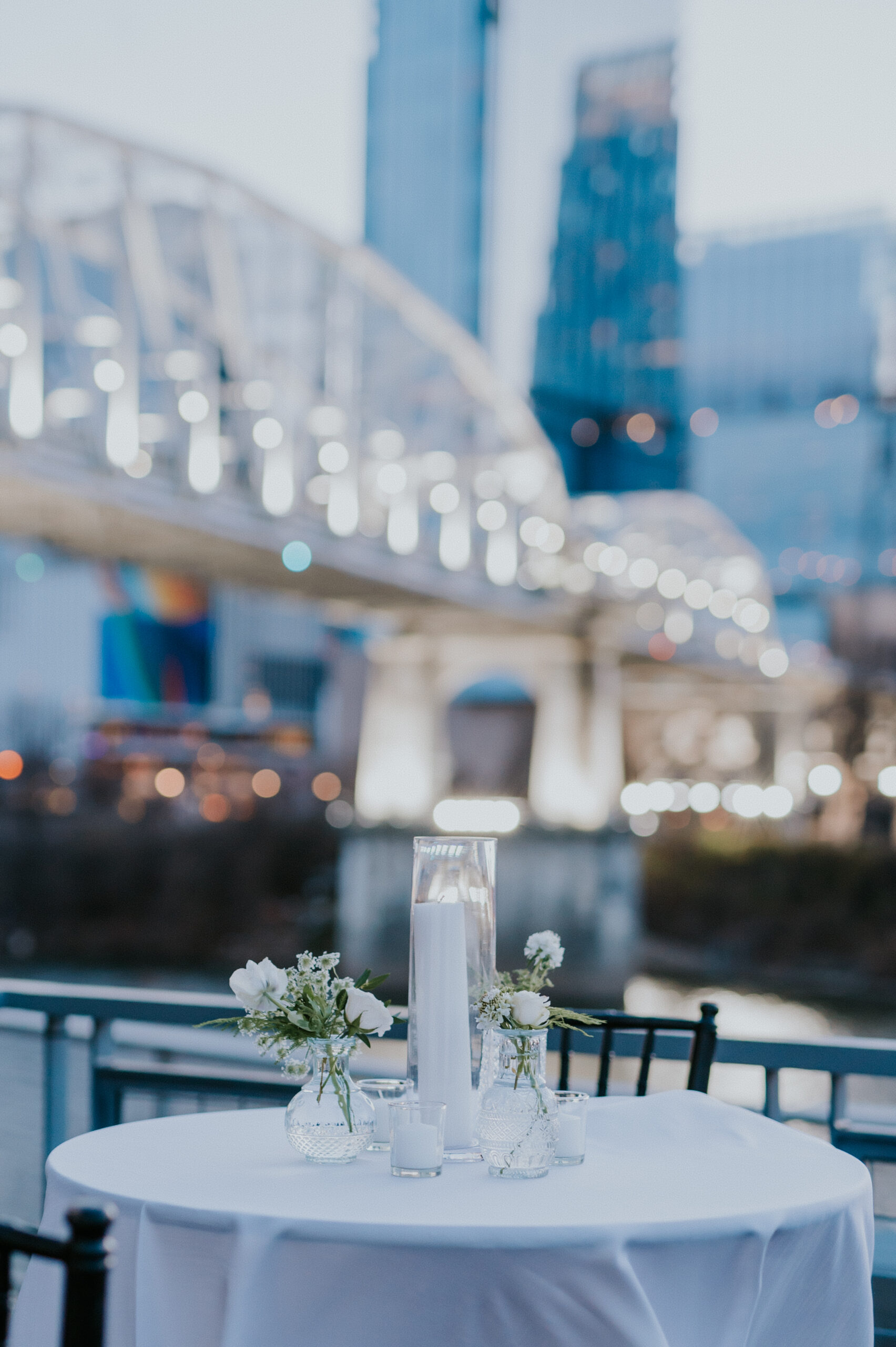 Outdoor wedding tablescapes with bridge building and Nashville skyline in background