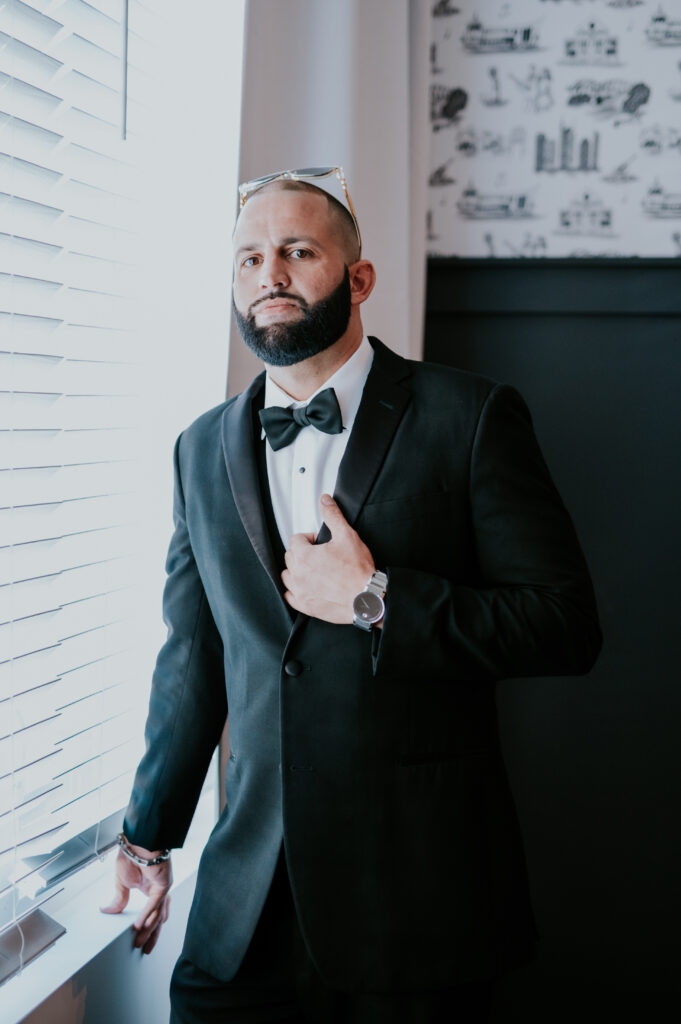 Groom holding jacket lapel after getting ready for wedding