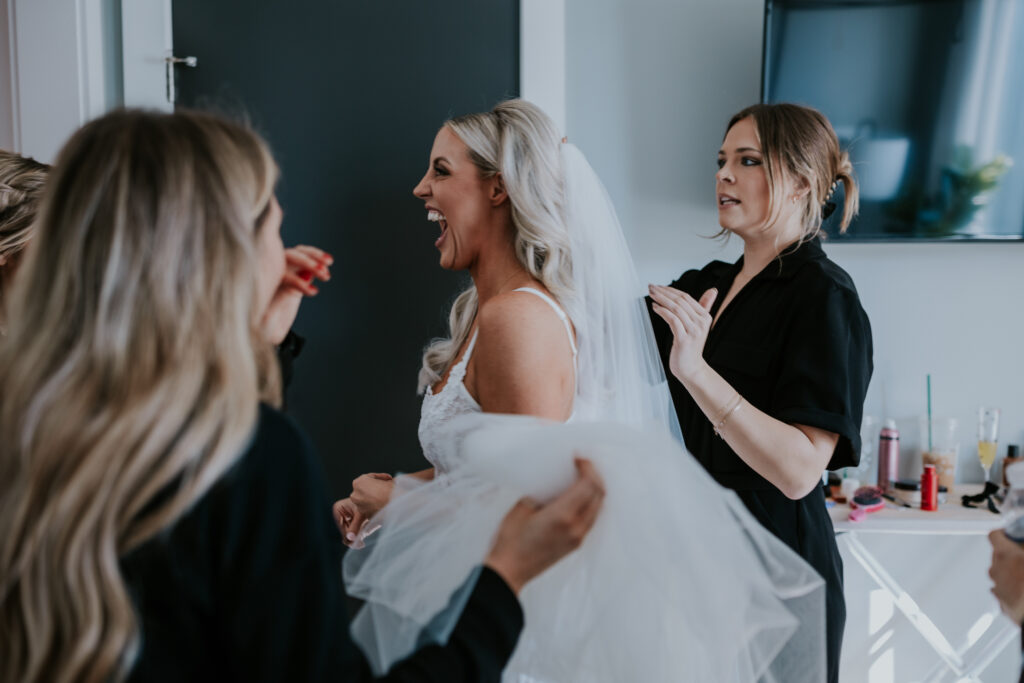 Bride getting ready with help from her bridesmaids before bridge street building wedding