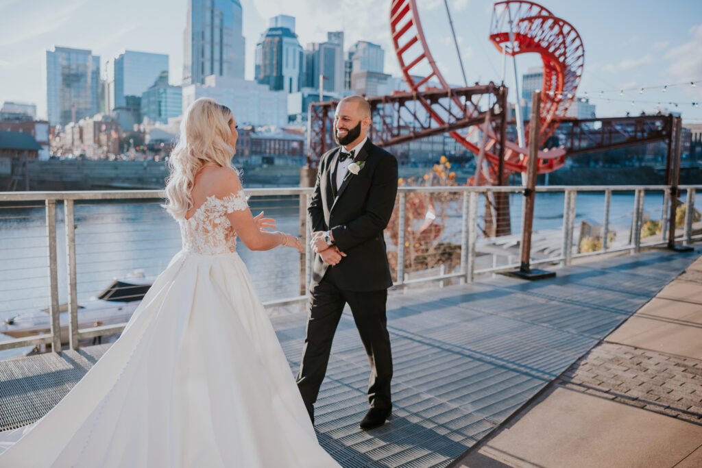 groom sees bride for the first time on wedding day in wedding gown at the bridge building in Nashville