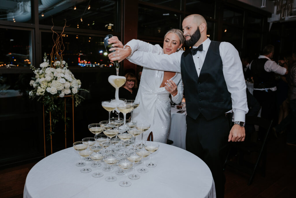 Nashville wedding photographer captures bride and groom pouring champagne in tower
