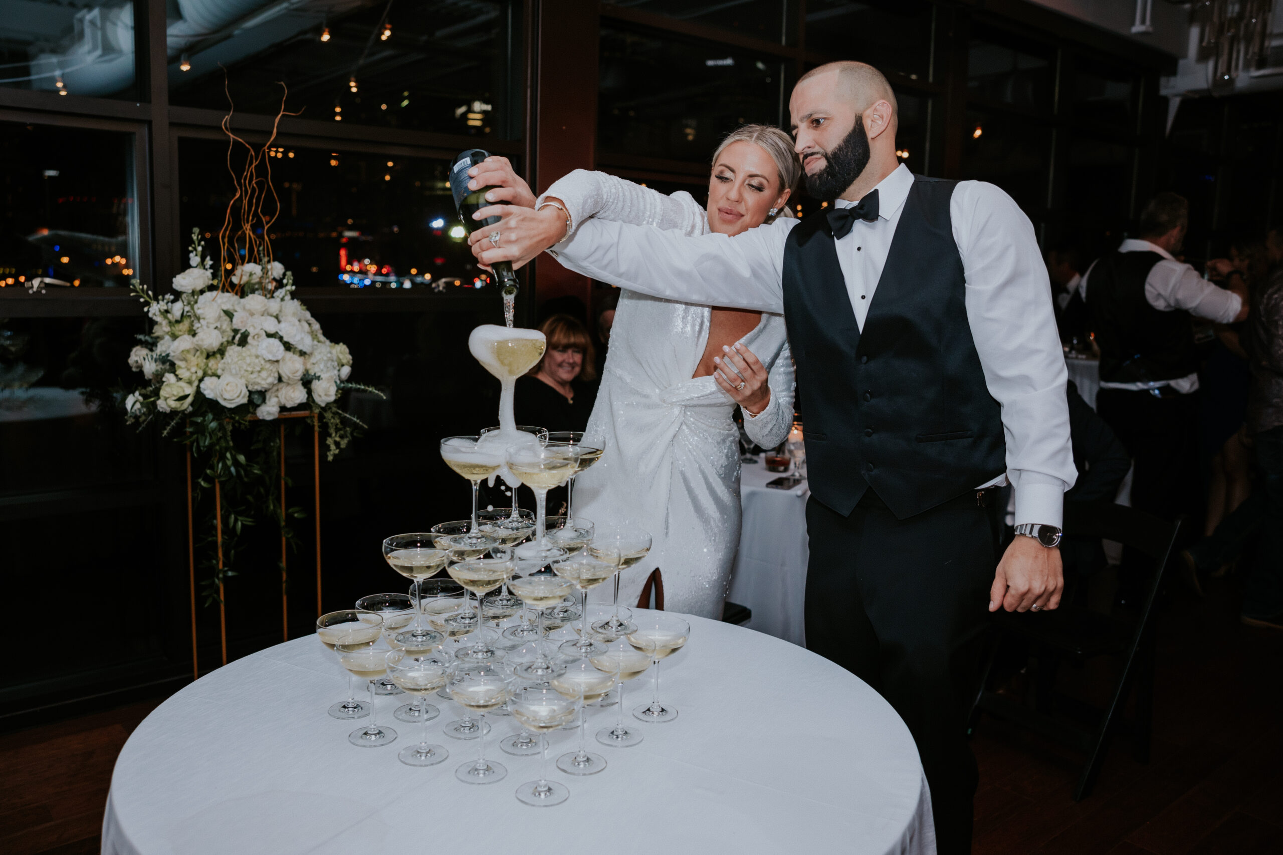 Nashville wedding photographer captures bride and groom pouring champagne in tower