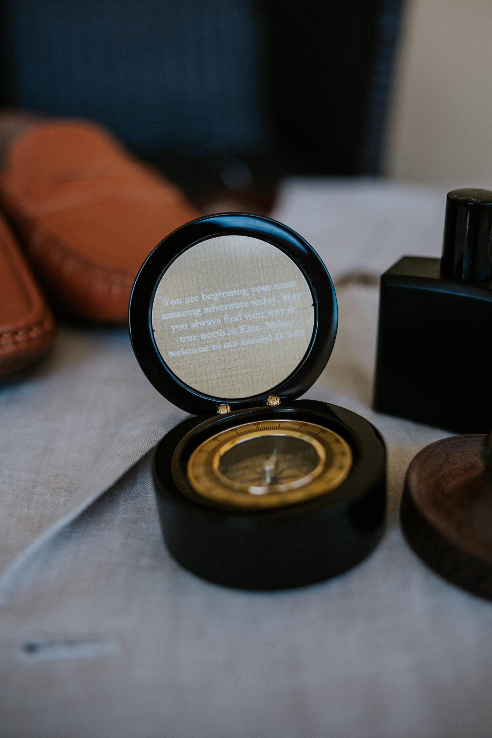 A sentimental compass with an engraved message, surrounded by wedding accessories and shoes.