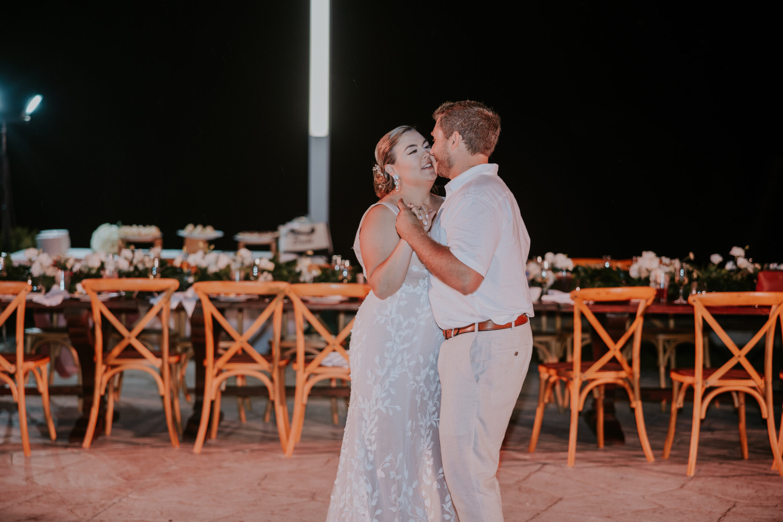 Couple sharing their first dance at an outdoor reception under the night sky.