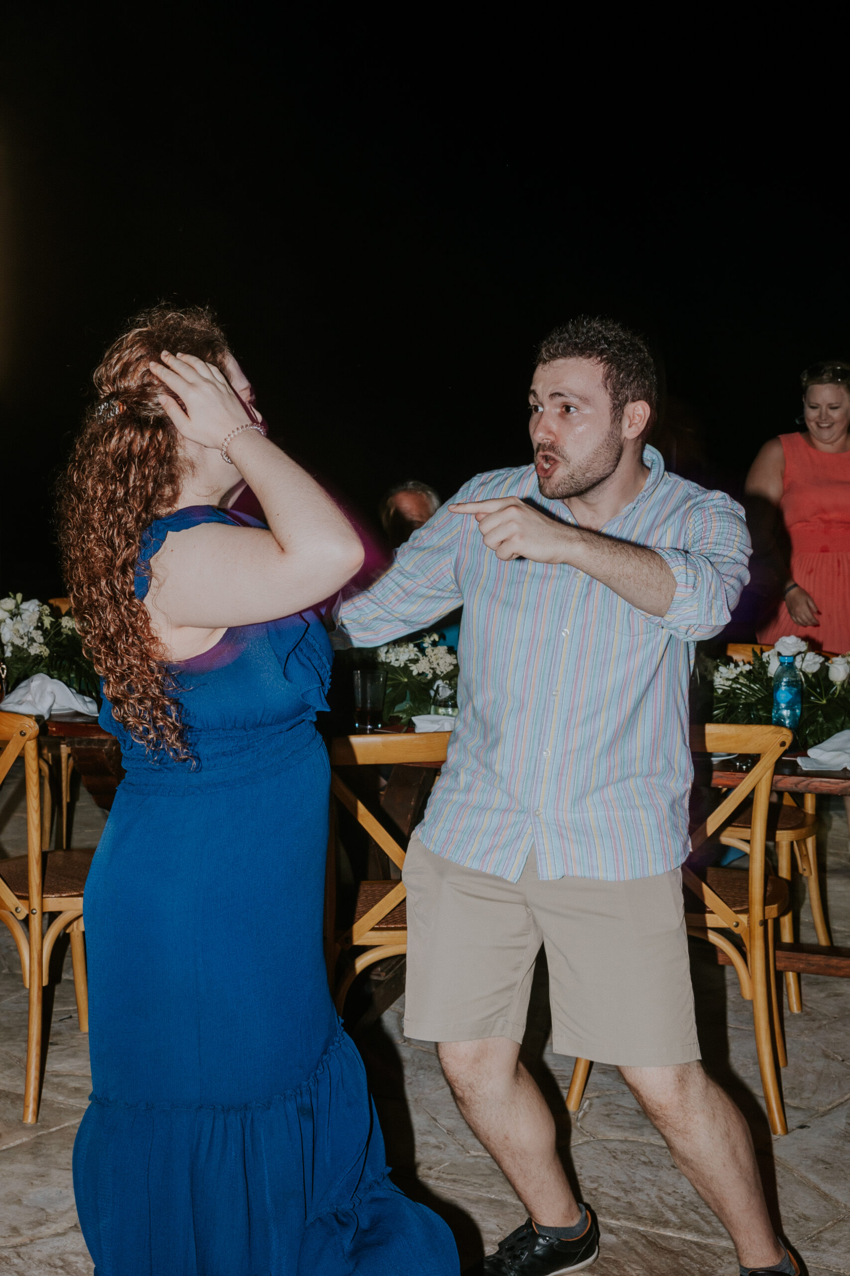 Guests dancing and laughing during the lively outdoor wedding reception.