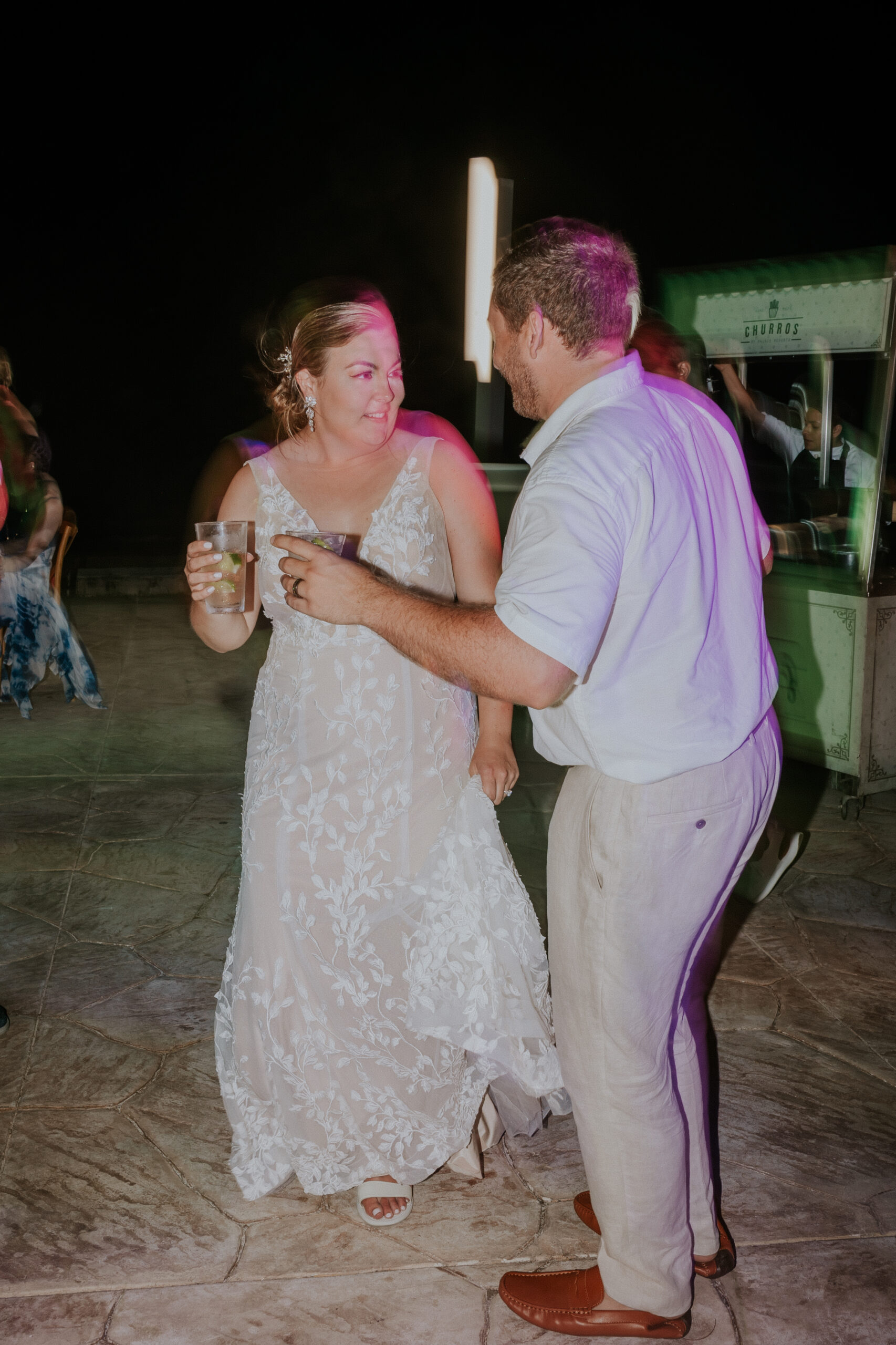 Bride and groom enjoying drinks together on the dance floor at their Mexico destination wedding.