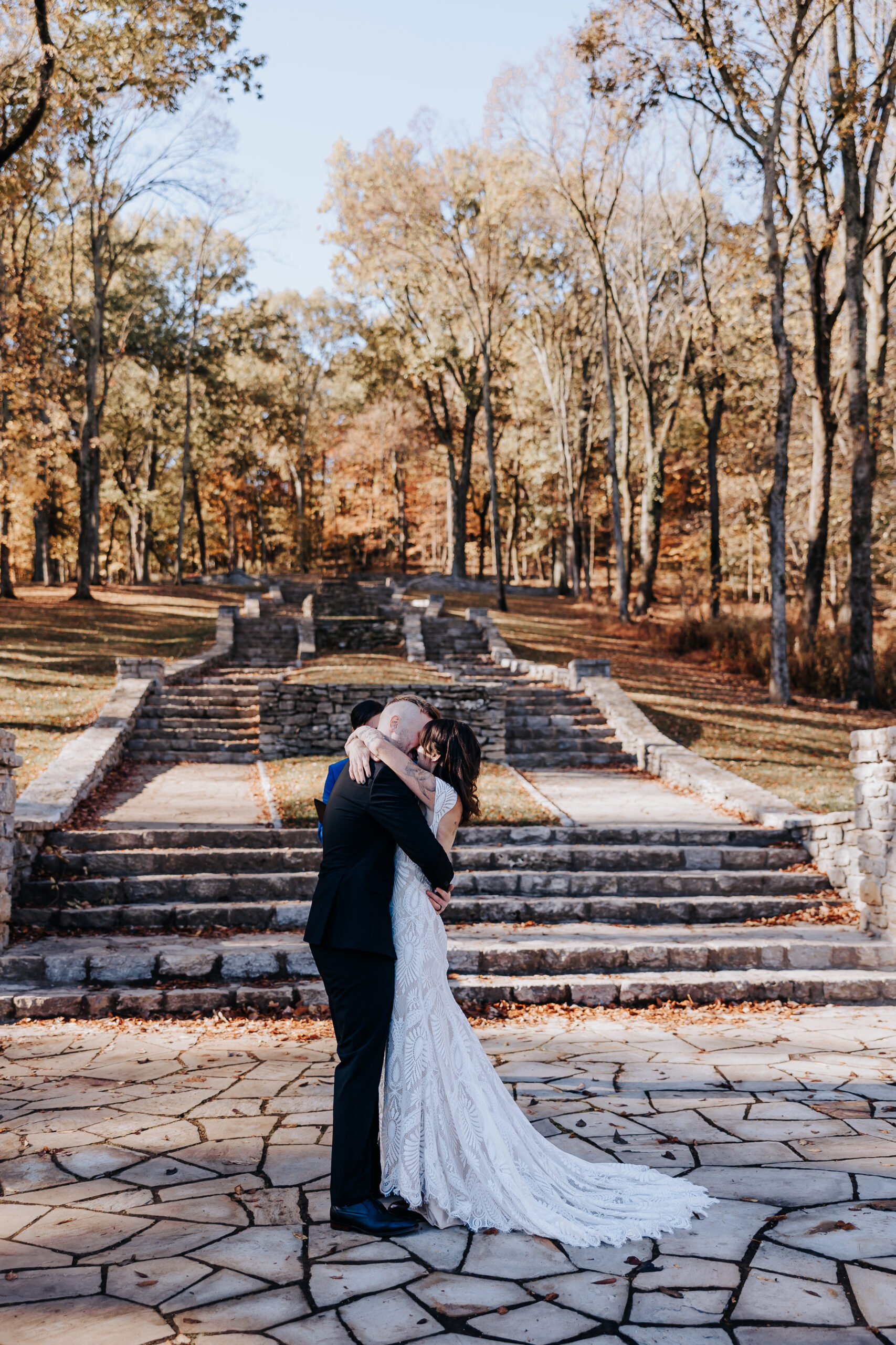 Bride and groom share their first kiss as newlyweds on the stone patio steps in the heart of a fall wedding in Nashville.