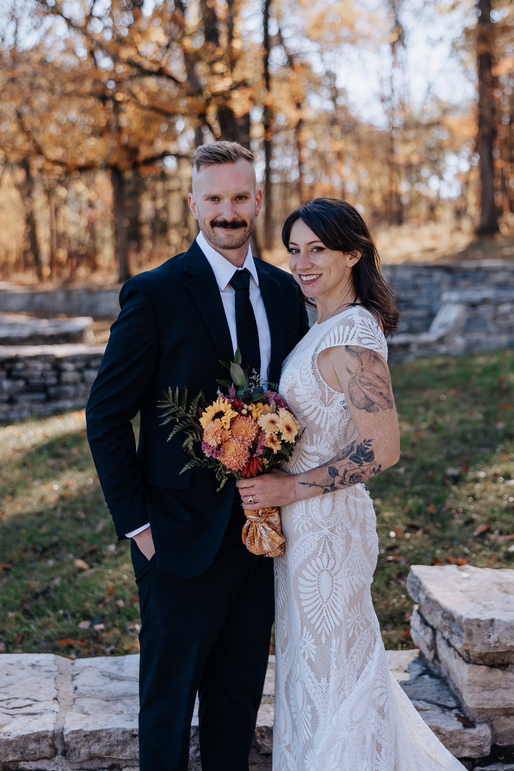 Bride and groom standing together, smiling with a rustic bouquet in hand — the perfect snapshot from their wedding in Nashville.