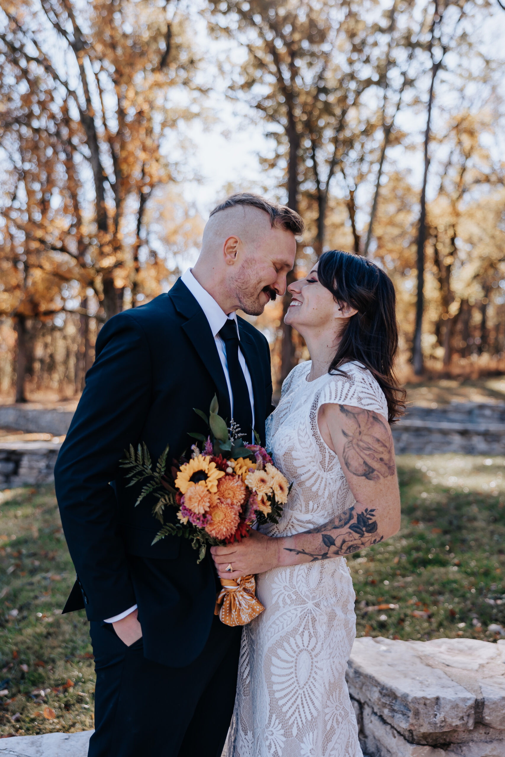 Bride and groom share a sweet moment with foreheads touching, holding a warm-toned bouquet during their Nashville wedding.