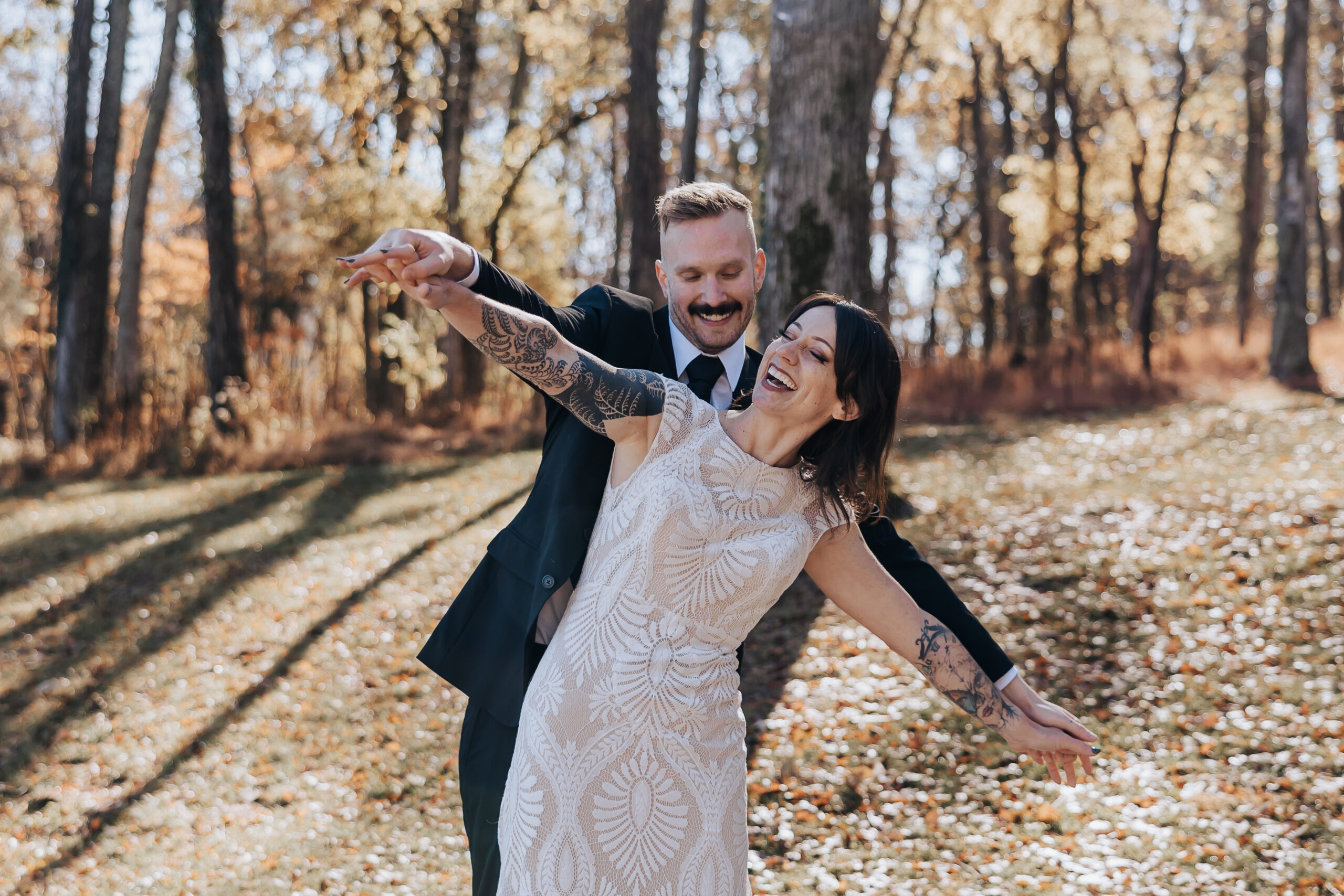 Couple laughing and reenacting the Titanic pose in a golden forest, full of joy and autumn energy.