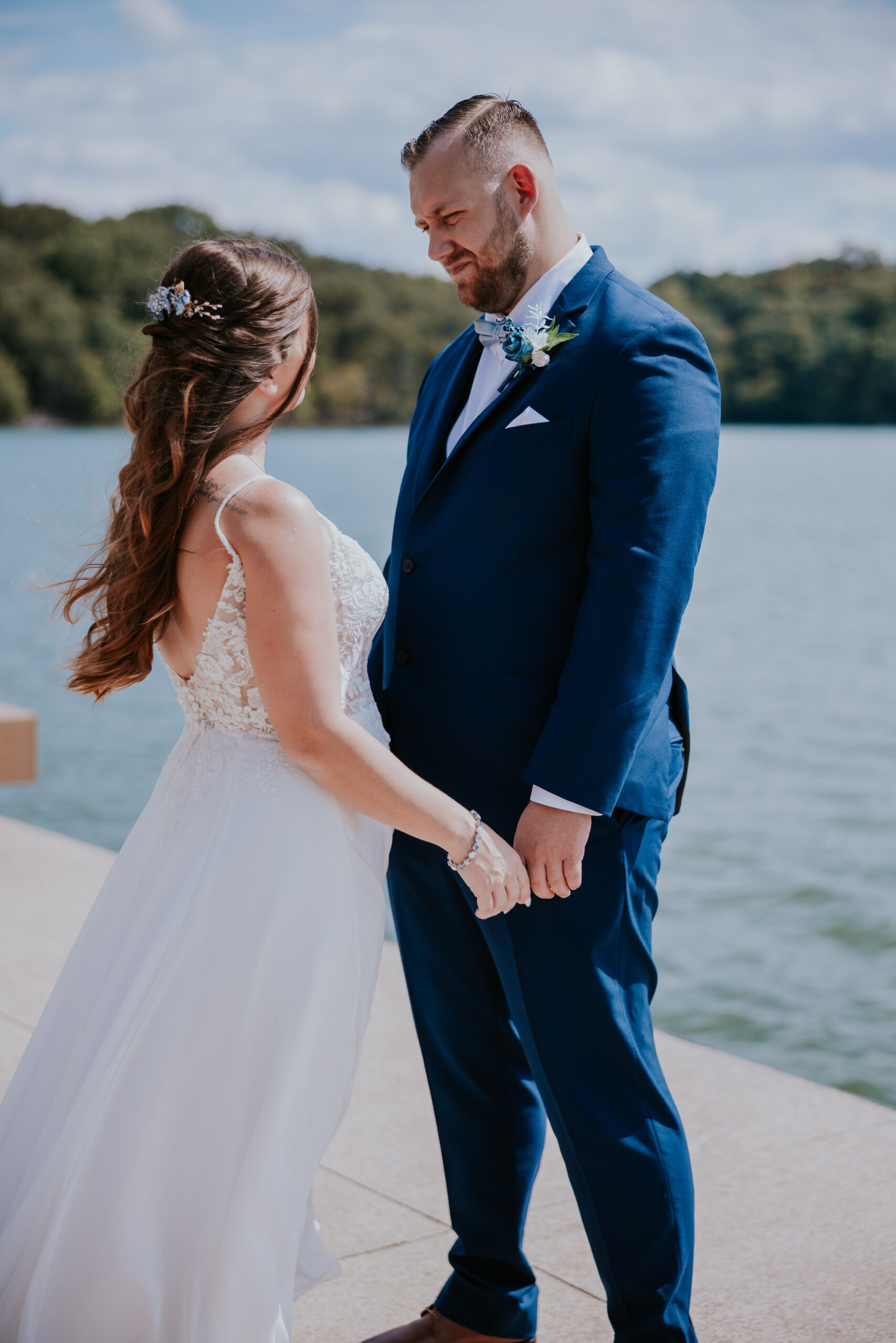The bride and groom holding hands and gazing at each other beside the water at Fall Creek Falls, capturing quiet connection and natural beauty.