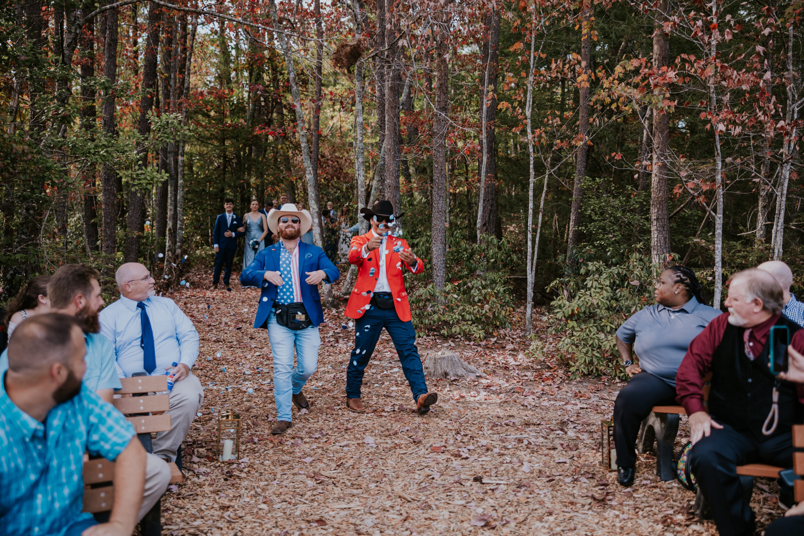 Two guests in cowboy hats and playful suits blow bubbles down the aisle, bringing laughter and charm to the ceremony entrance — a memorable moment filled with unique wedding ideas.