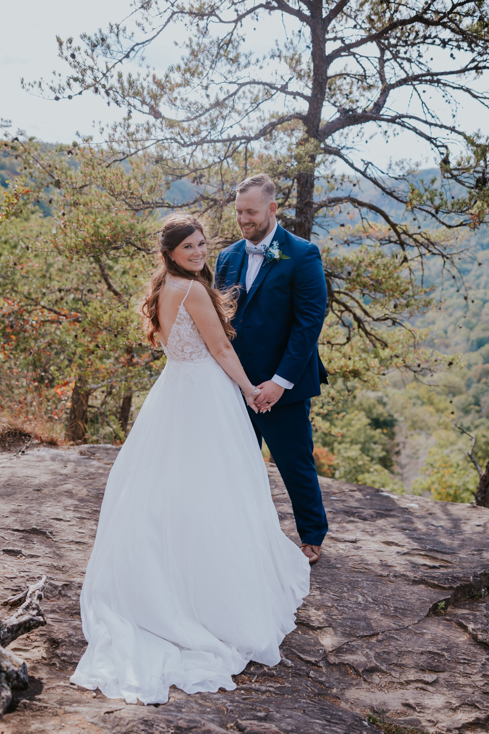 Bride and groom sharing a quiet moment on a rocky overlook with mountain views — an adventurous take on unique wedding ideas for nature lovers.