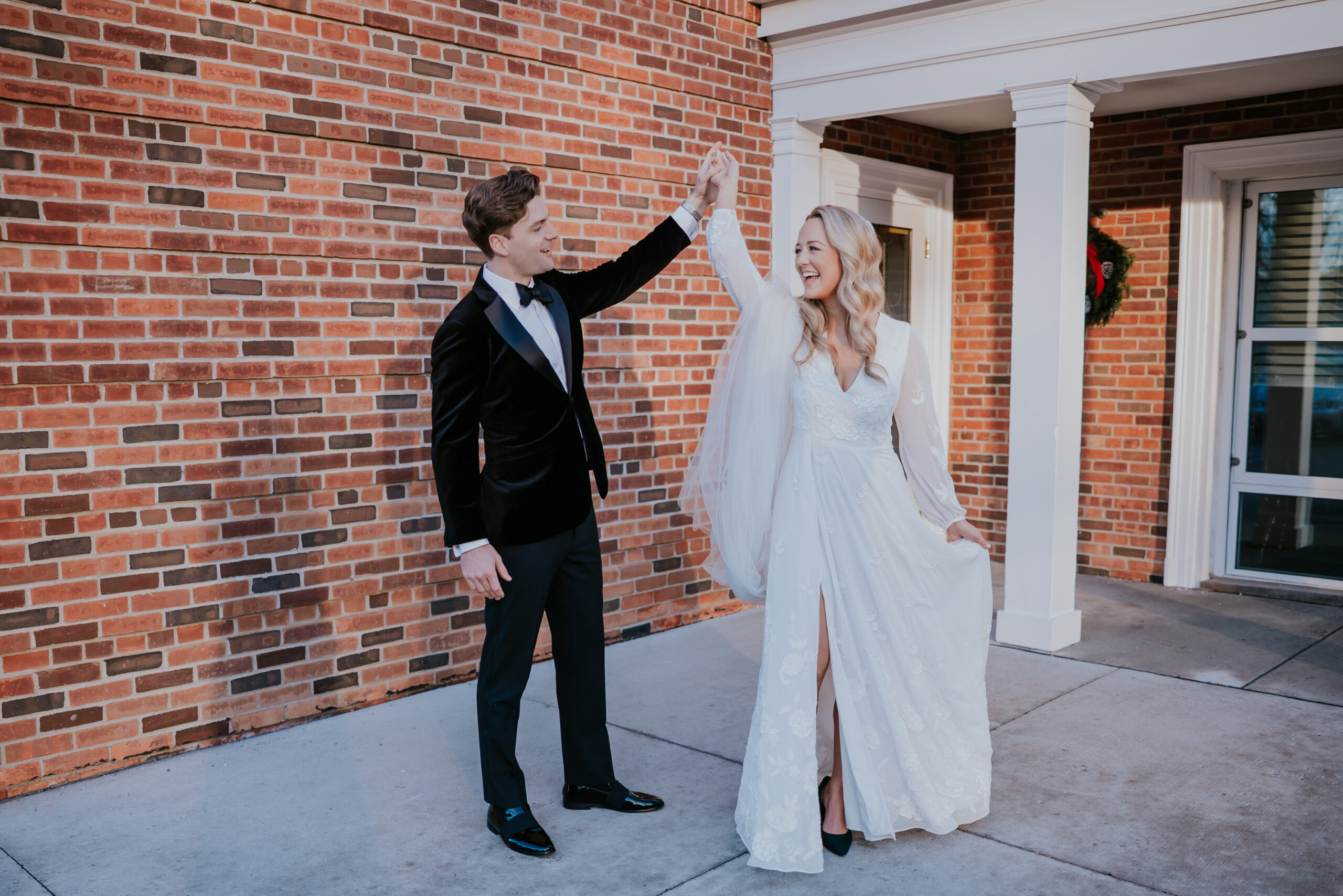 Groom twirling the bride in her wedding gown outdoors, photographed by a wedding photographer in Minnesota.