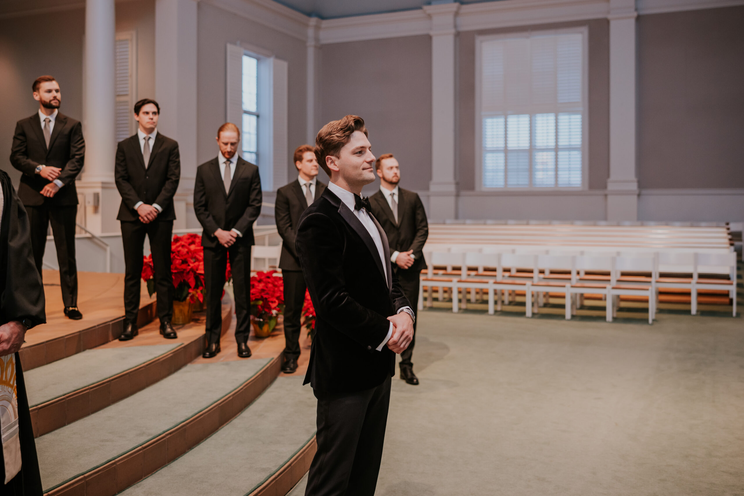 Groom standing at the altar, smiling as he waits for his bride.