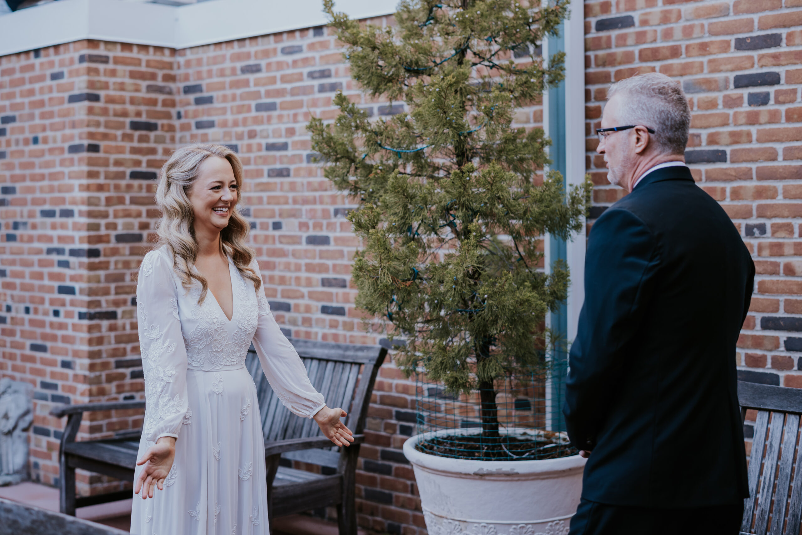 Bride smiling during a first look moment with her father, captured by a wedding photographer in Minnesota.