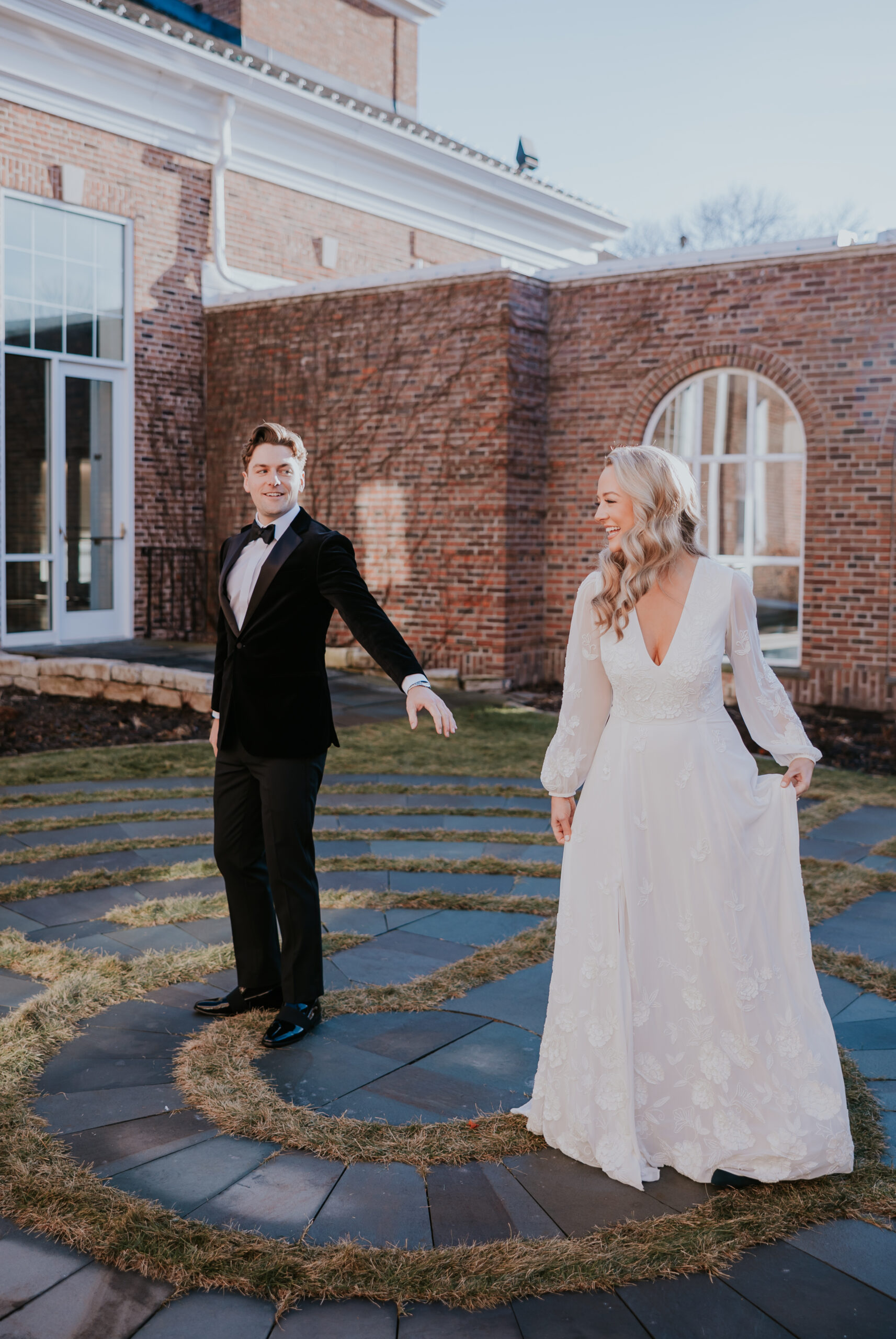 Bride and groom walking hand in hand, the bride lifting her gown slightly, photographed by a wedding photographer in Minnesota.