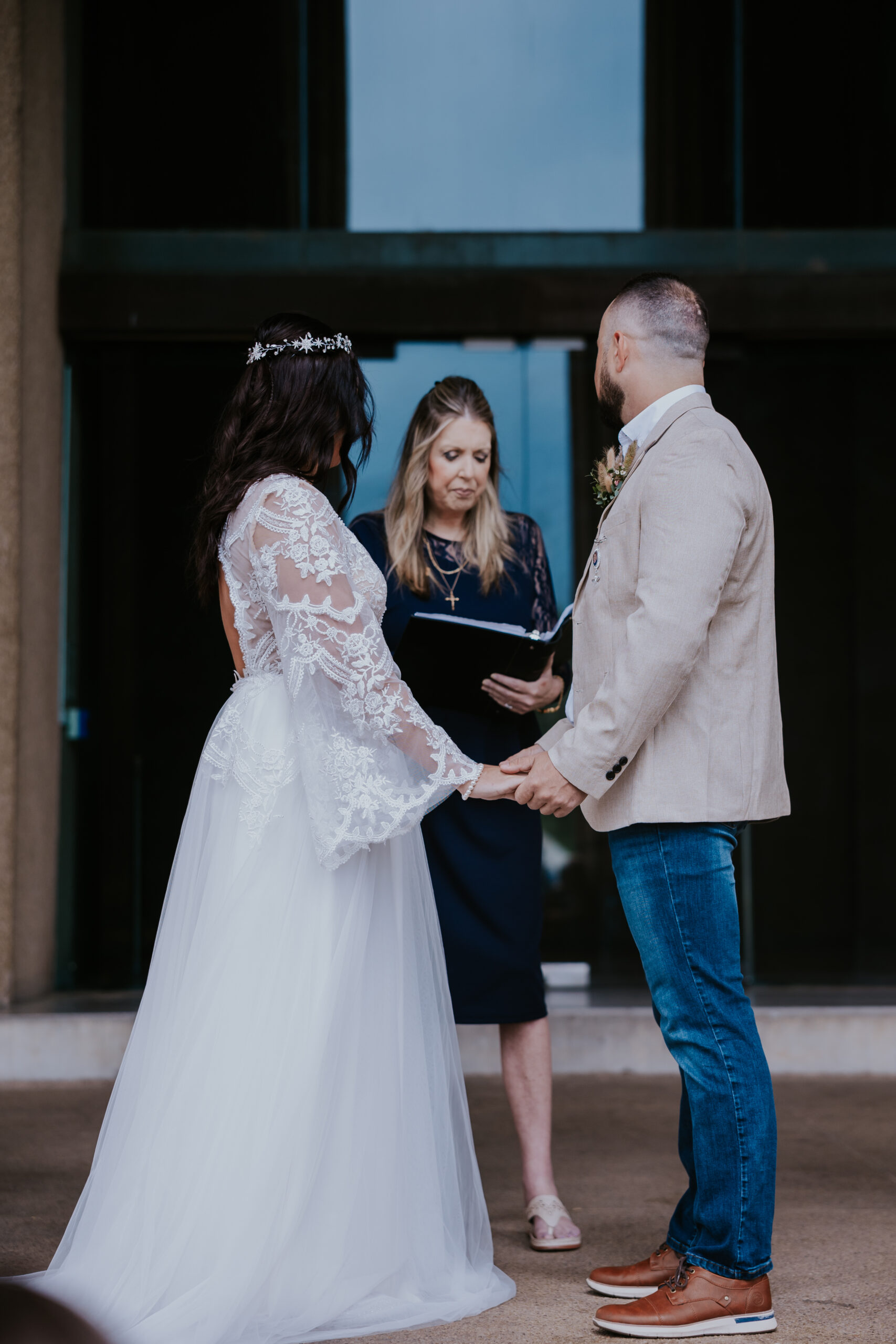 Close-up of the couple holding hands as the officiant begins their wedding ceremony.
