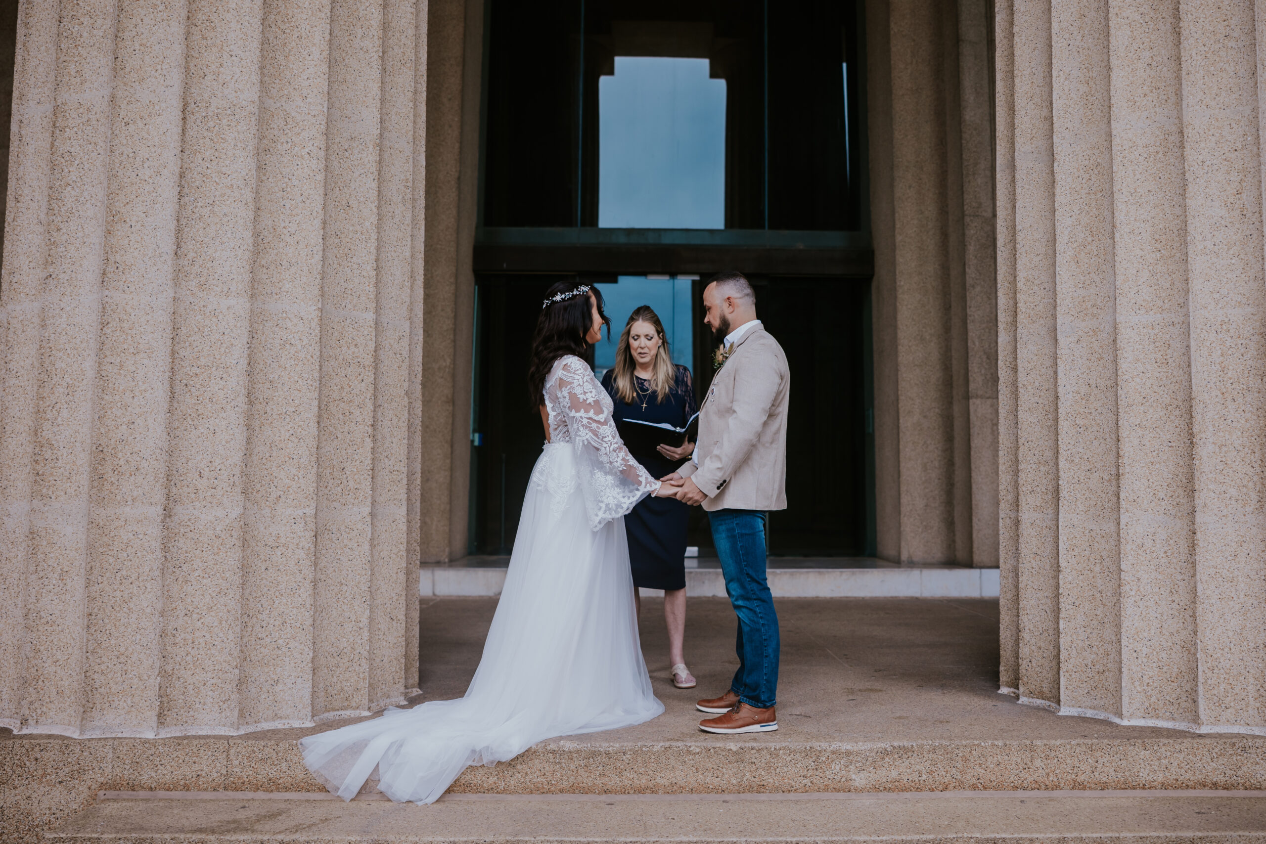 Bride and groom standing in front of an officiant, holding hands during their Nashville wedding ceremony—captured by a travel wedding photographer.