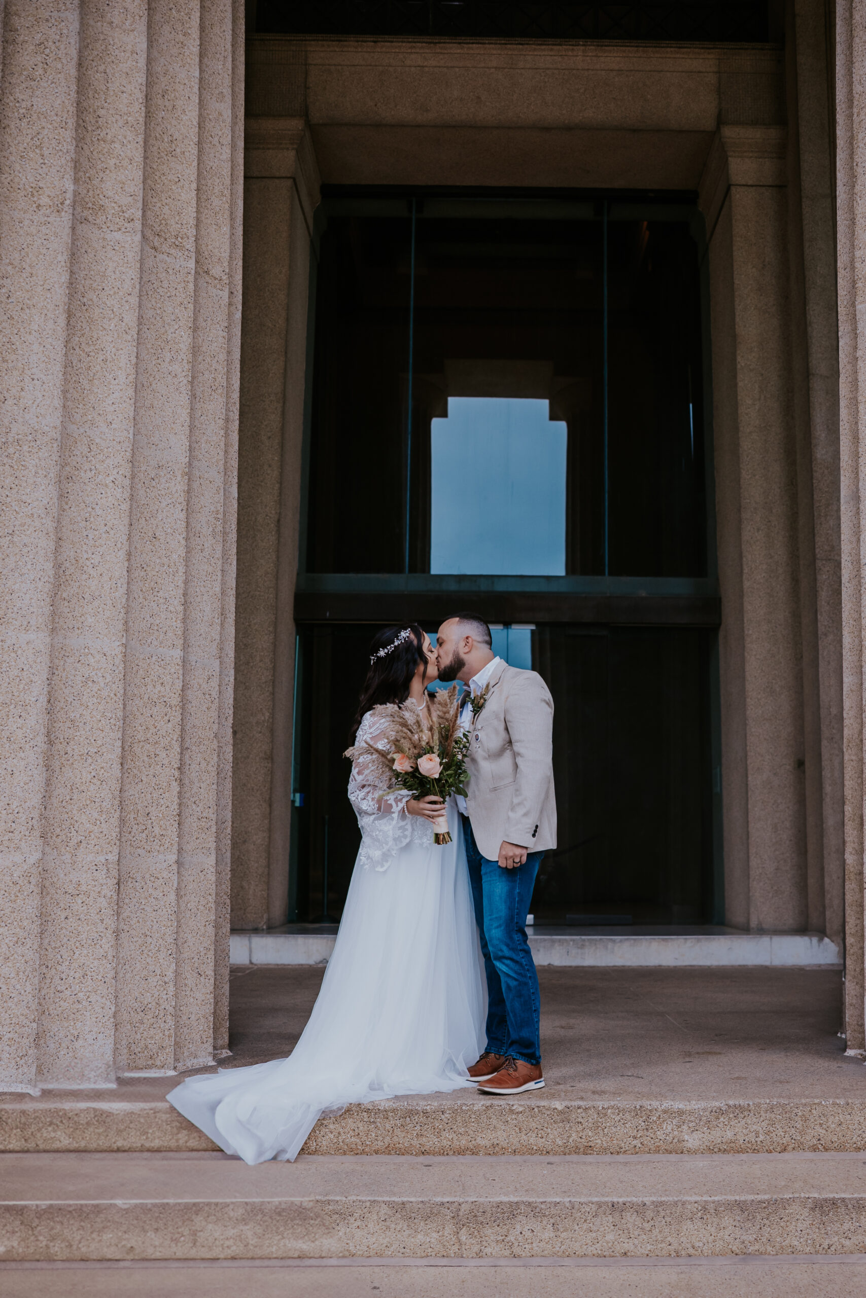 Elegant wedding kiss on historic steps, captured in timeless style by a travel wedding photographer.