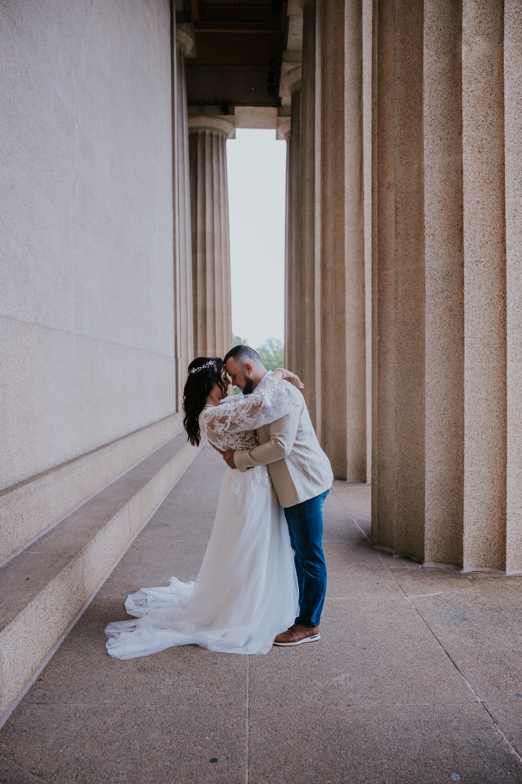 Bride and groom share an intimate kiss surrounded by grand architecture, beautifully documented by a travel wedding photographer.