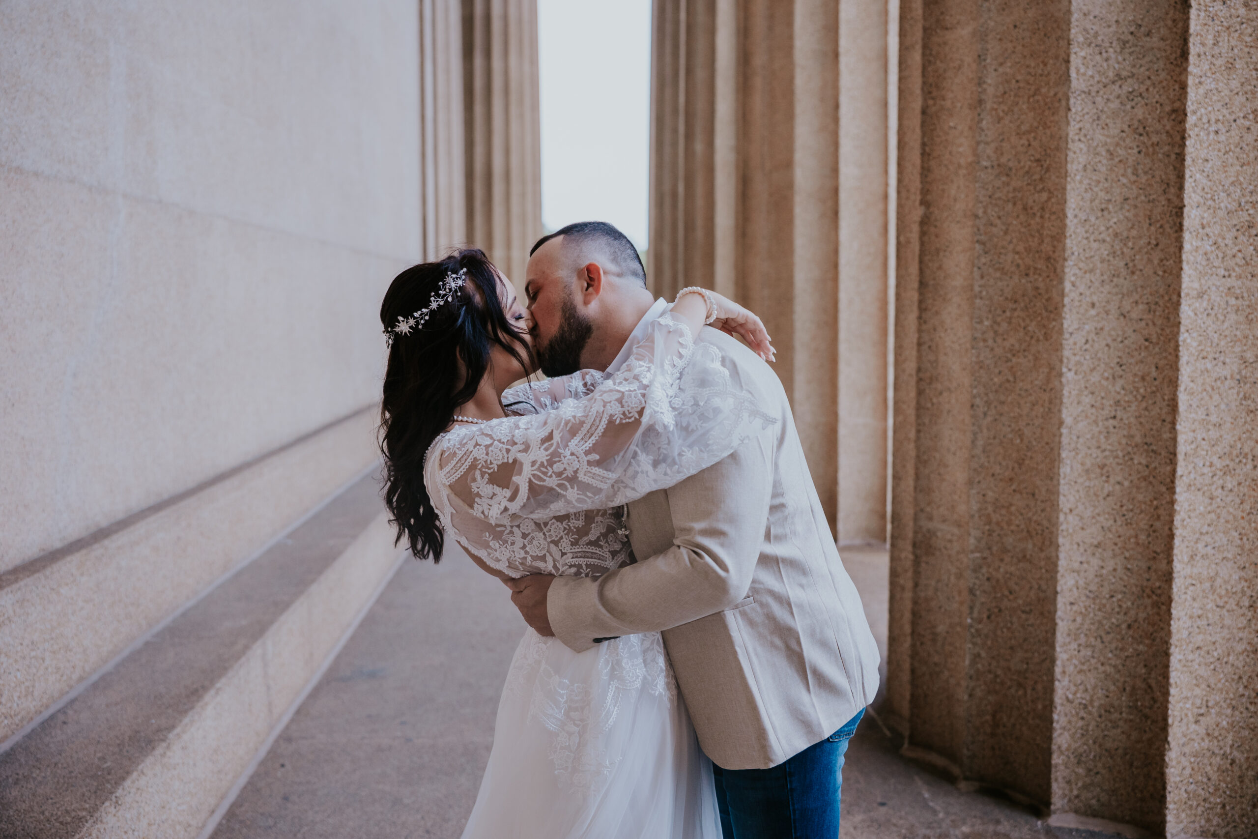Romantic dip and kiss between bride and groom among towering stone columns—an epic moment for any travel wedding photographer to capture.