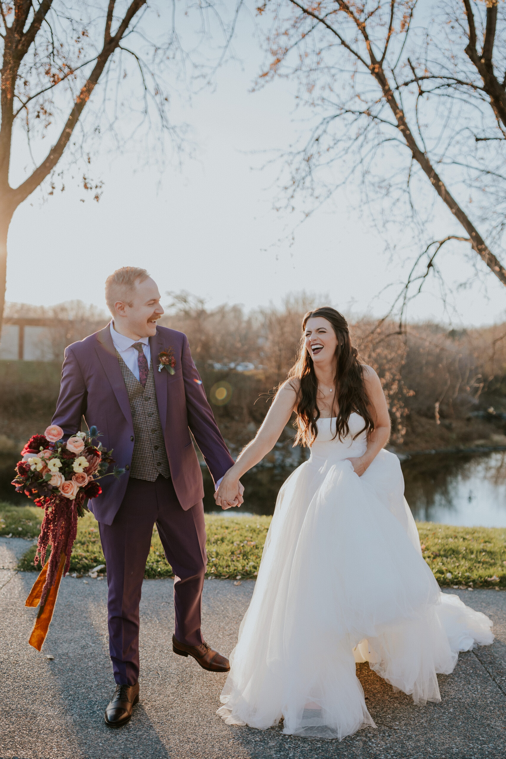 Bride and groom holding hands and laughing during golden hour portraits, captured by destination wedding photographers.