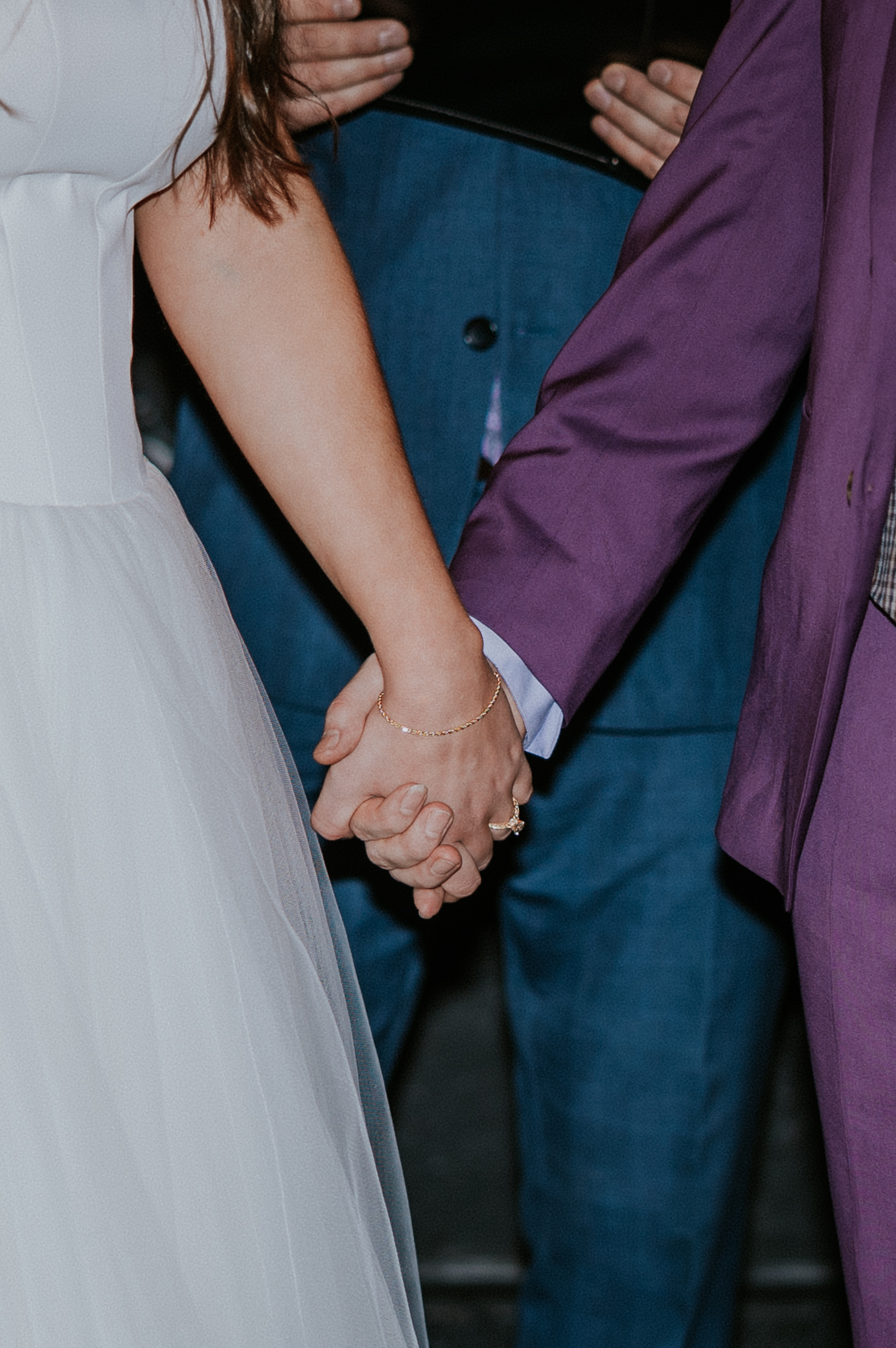 Close-up of the couple holding hands during their wedding ceremony, a moment filled with connection.