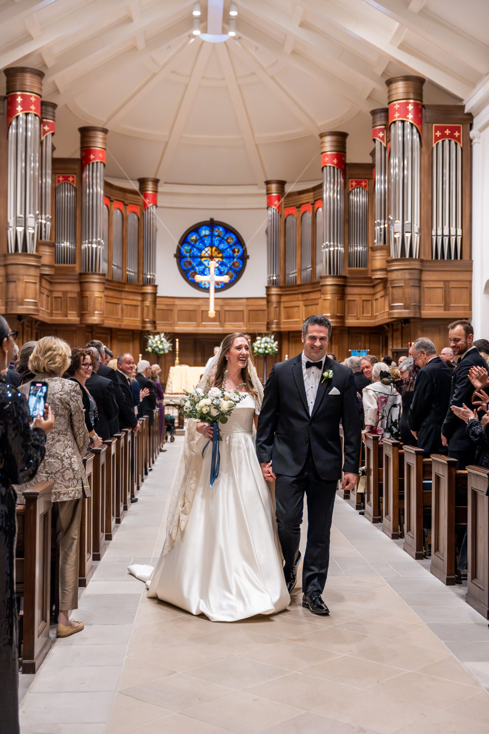 Just married and full of joy, the couple walks down the aisle at a stunning cathedral—moments like these are what wedding photographer packages are made for.