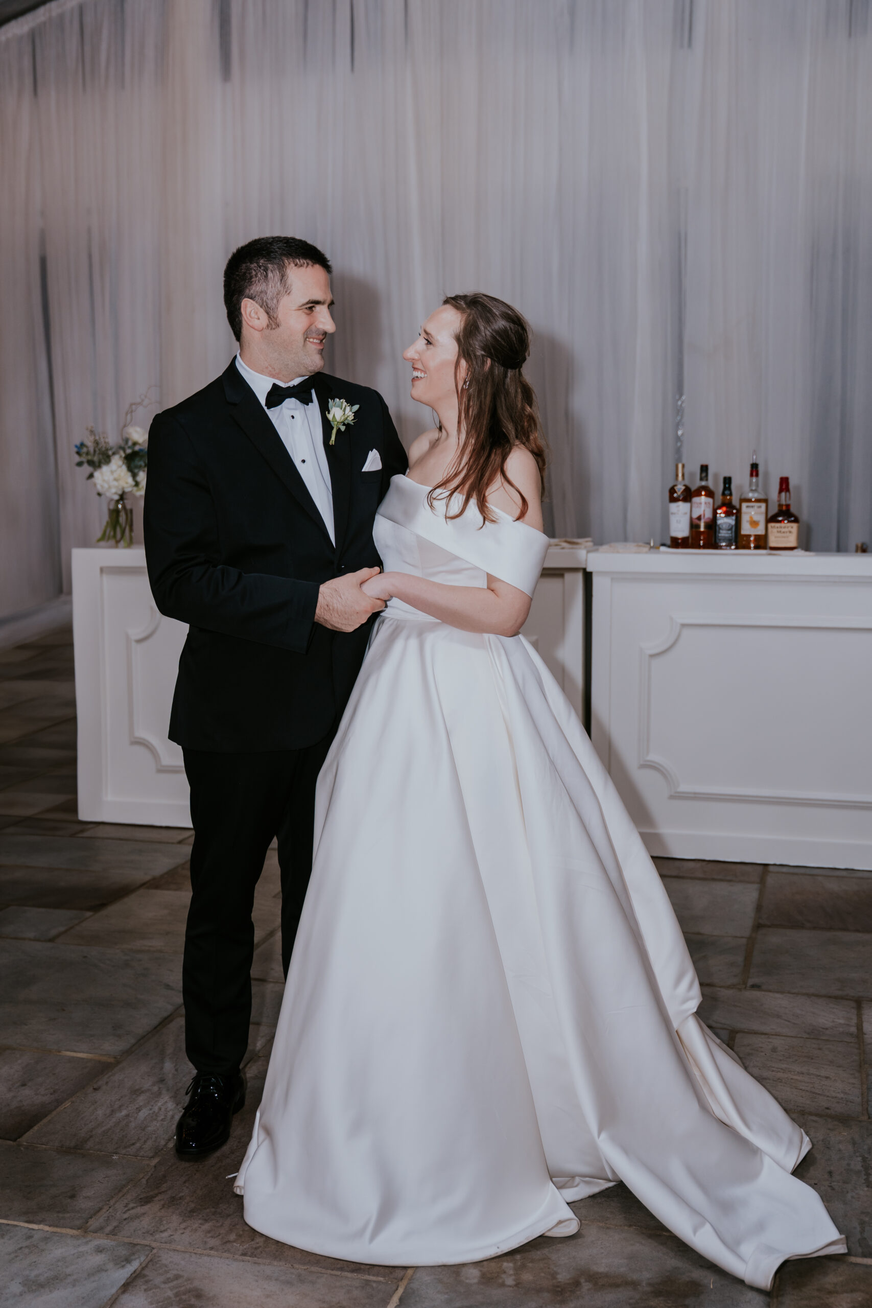 Bride and groom share a loving glance during their reception, a candid moment often highlighted in wedding photographer packages.