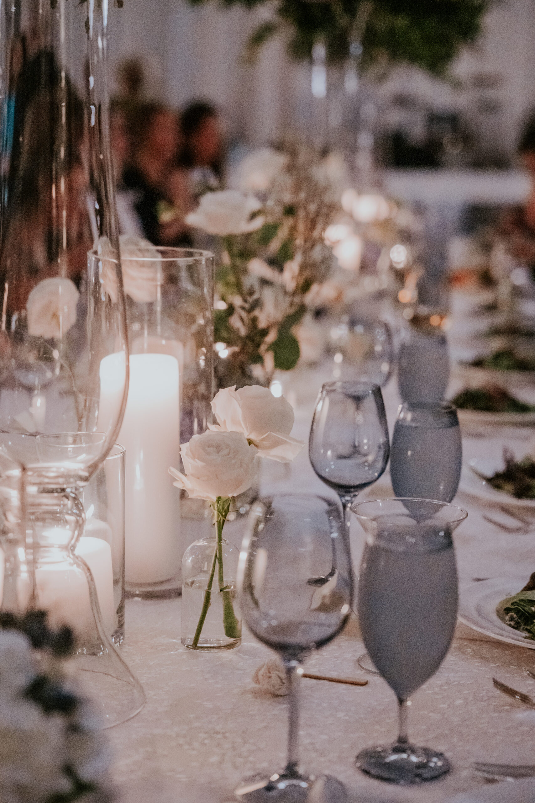A dreamy close-up of a candlelit reception table lined with soft florals and elegant glassware.